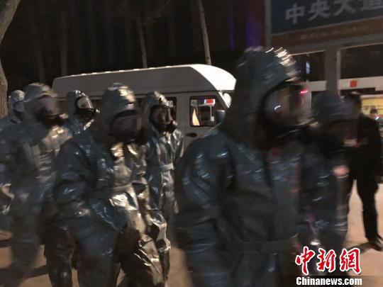 十几名身着防护服的人员头戴面具进入事发地。　胡健 摄